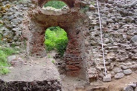 Der Eingang zum Vorraum ist teilweise beräumt, über den Gewölberesten des Vorraums eine Rundbogenöffnung, Pflanzenbewuchs auf dem Geröll im Hauptsaal (Aufnahme 2002)